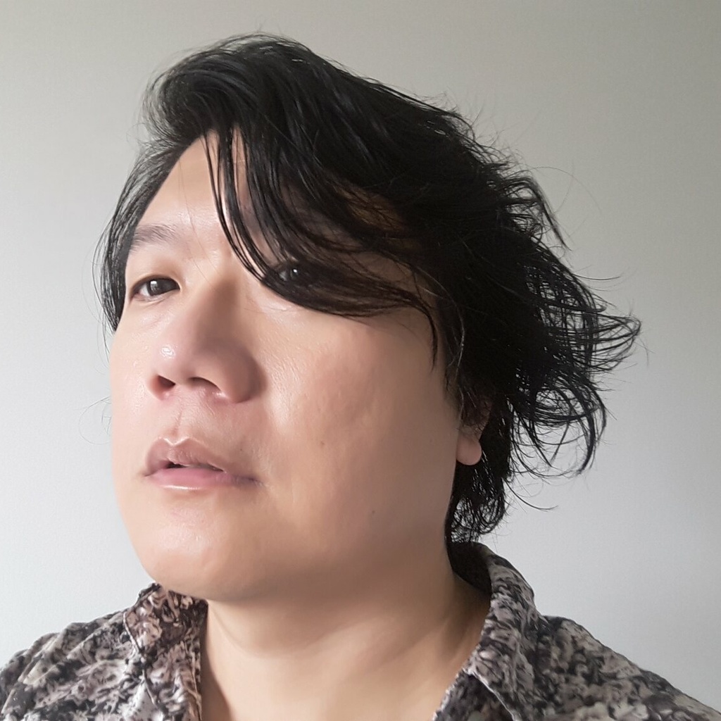 person looking up to the left corner of the picture with wavy black hair obscuring one eye