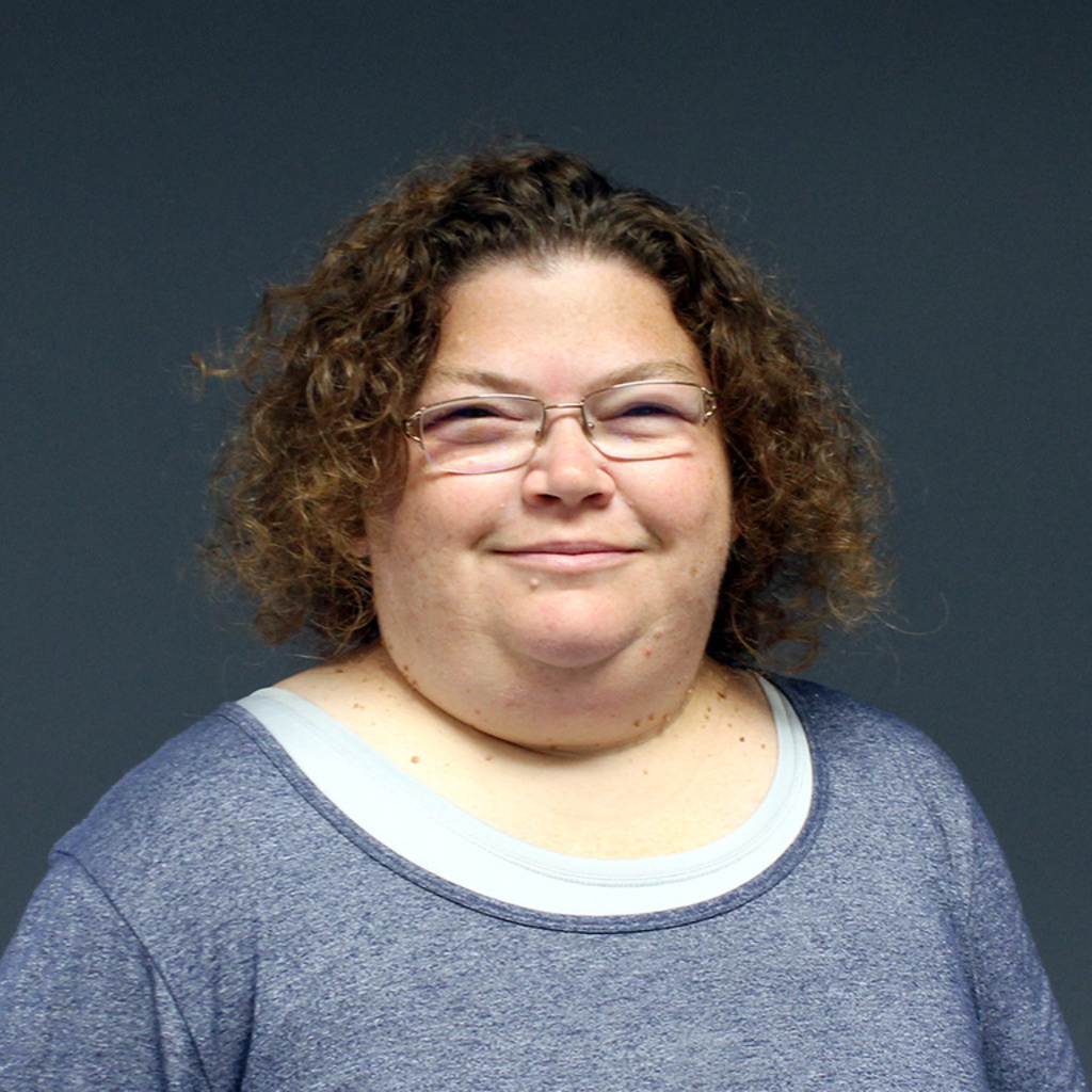 woman with short curly hair and glasses