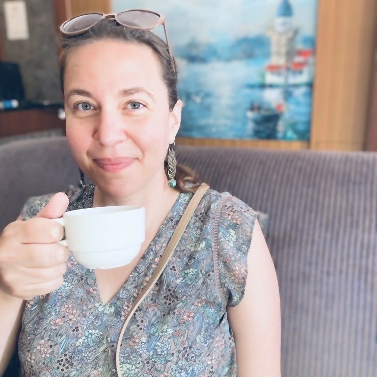 female presenting individual holding a coffee mug