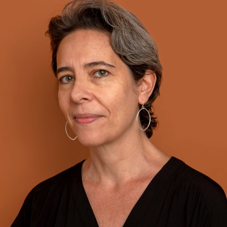 female presenting individual with short hair and hoop earrings